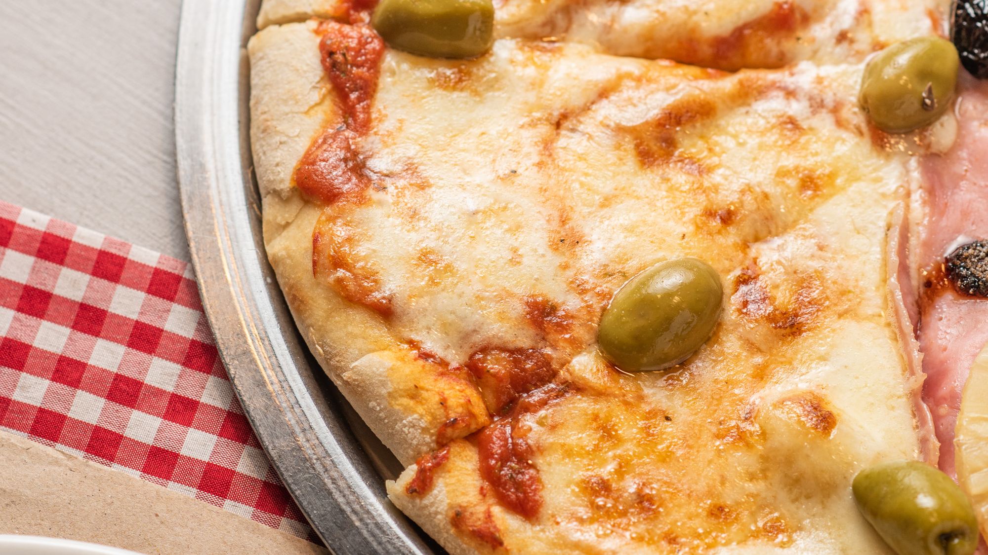 Pizza mozzarella sobre mantel a cuadros